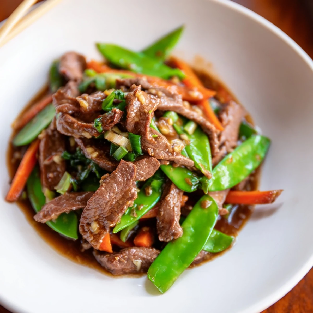 Stir-fried carrots and beef tossed in a glossy sauce for Beef Stir Fry with Snow Peas and Carrots.