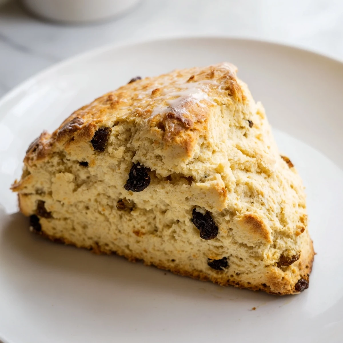 Close-up of warm Irish Soda Bread Scones reveals a crisp exterior and soft, flaky layers, ideal for breakfast or afternoon tea.