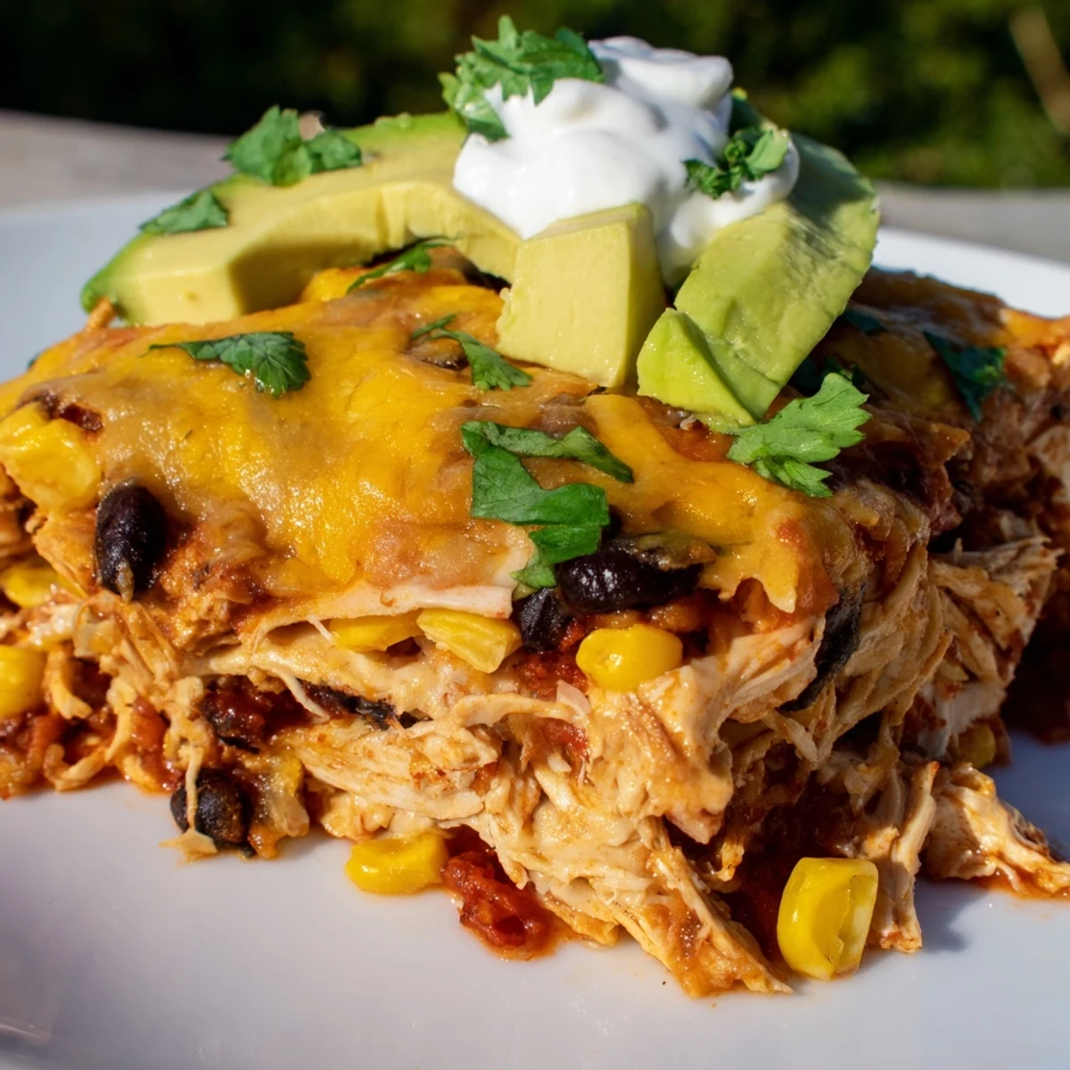 Gooey melted cheese topping the Chicken Enchilada Casserole with Cheese, served in a slice.