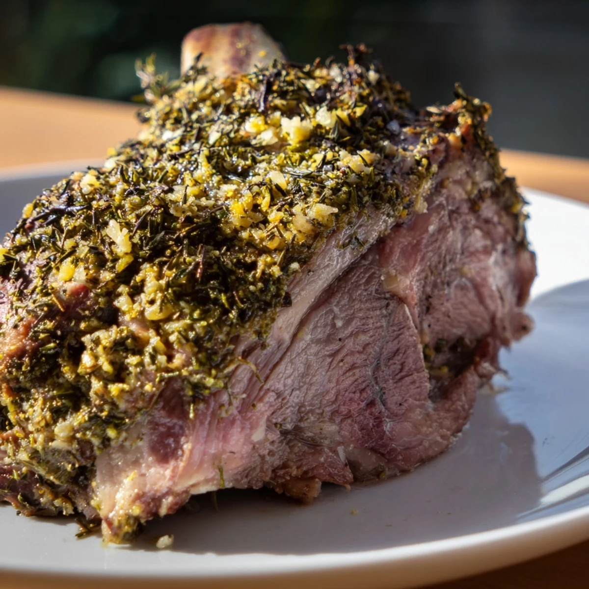 Golden, herb-crusted Roasted Lamb Shoulder rests on a platter, juicy meat flanked by roasted carrots and onions for a rustic Mediterranean feast.