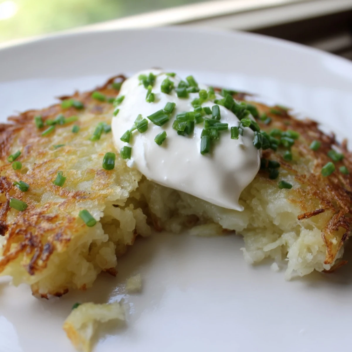 Sizzling Irish Boxty with Sour Cream pancakes are served hot as a comforting side dish, garnished with scallions and a pinch of salt.