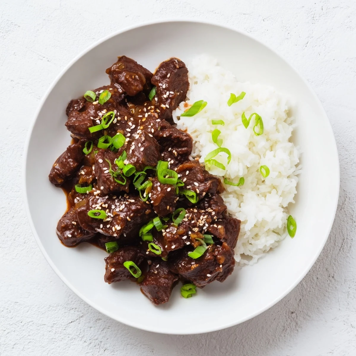 Crock Pot Korean Beef simmering in a rich, glossy sauce with sliced onions, ready to be served over rice.