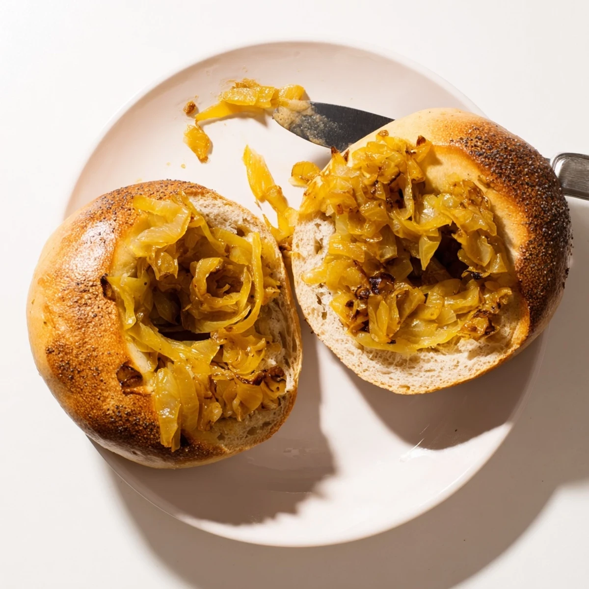 Sliced Sourdough Onion Bagels reveal chewy crumb texture, ready for cream cheese schmear at American breakfast.