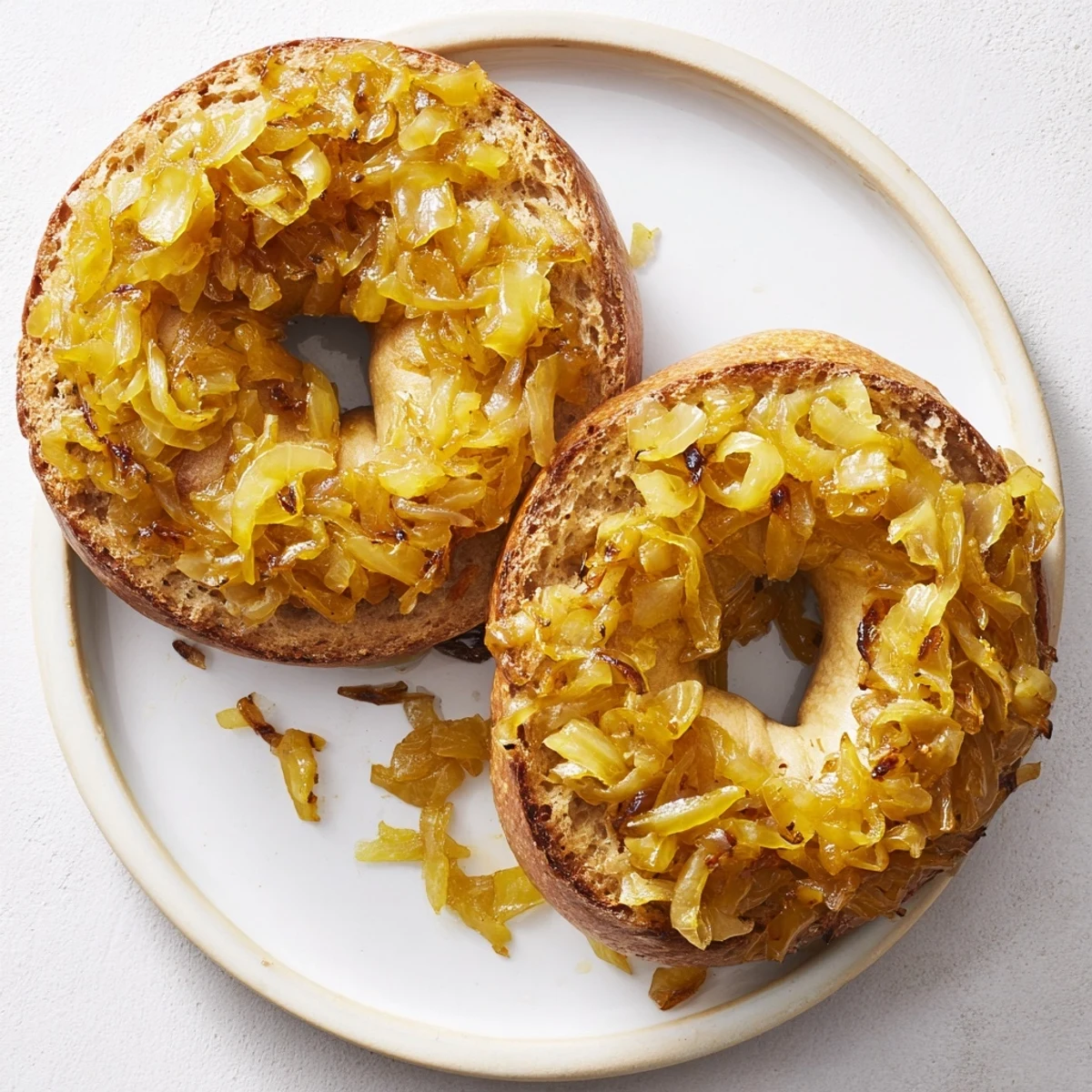 Steaming Sourdough Onion Bagels topped with sweet onions on wooden board, bakery-style brunch presentation.