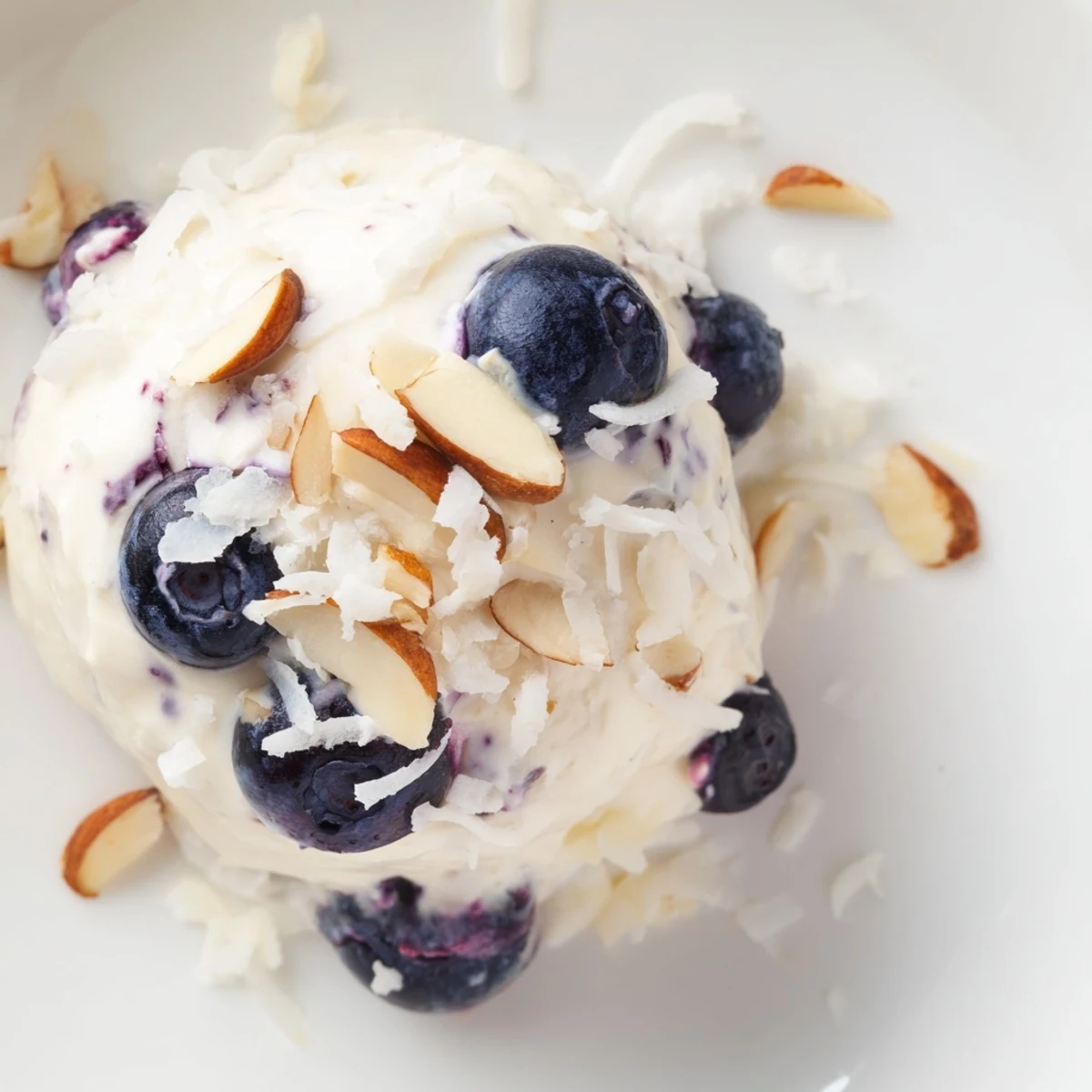 Close-up view of chilled Greek yogurt clusters featuring juicy blueberries embedded in smooth vanilla-sweetened cream