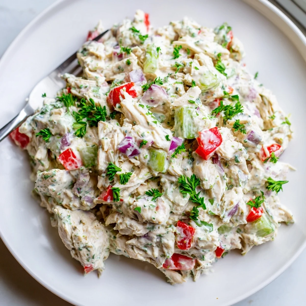 Light and protein-packed Greek yogurt rotisserie chicken salad featuring tender shredded chicken and colorful diced vegetables