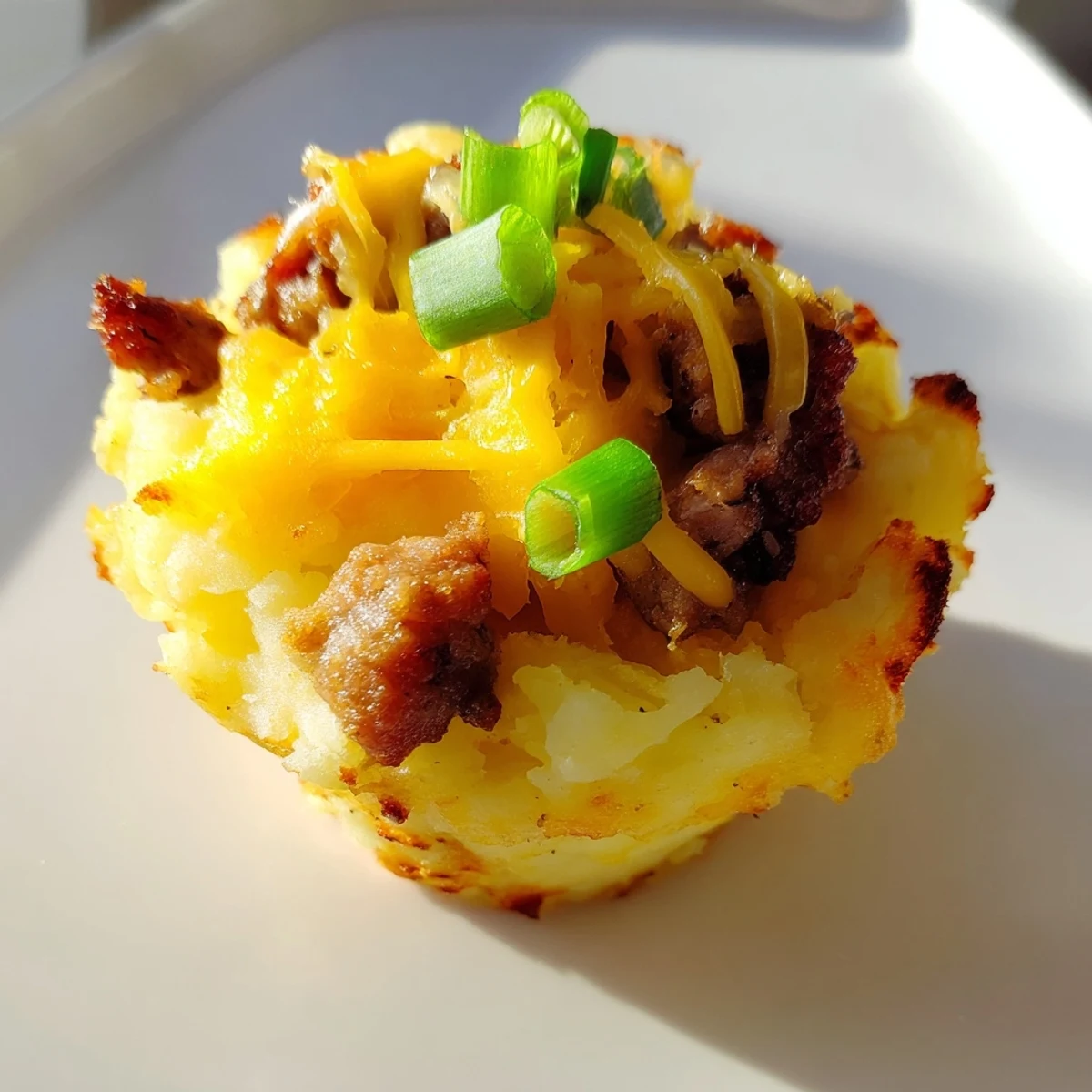 Festive St. Patricks Irish sausage and mashed potato cups served on a white platter with green garnish