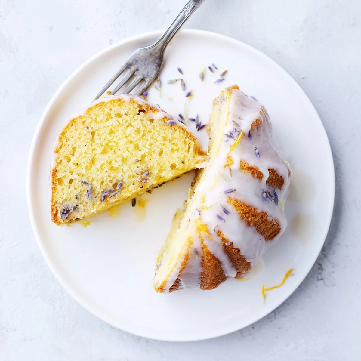 Golden slice of fragrant lemon lavender cake topped with tangy lemon glaze and garnished with culinary lavender flowers