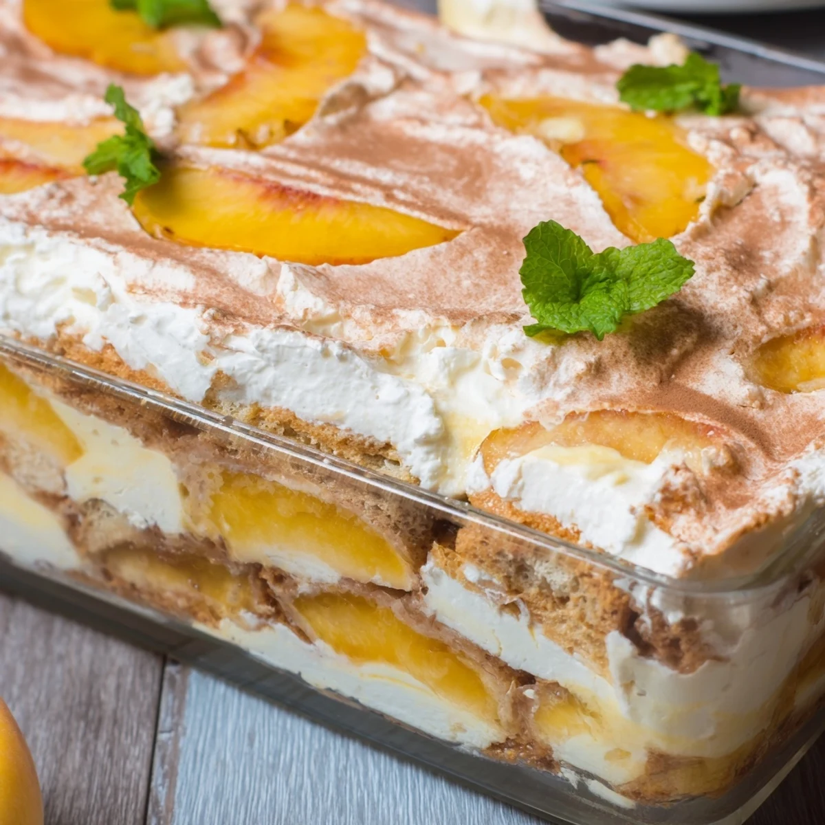 Summer peach tiramisu showing alternating layers of golden peaches and white mascarpone cream