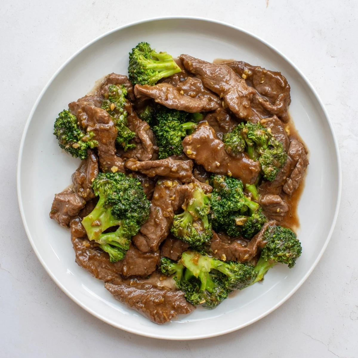 Homemade beef and broccoli stir fry sauce drizzled over sizzling beef and fresh broccoli in a hot wok