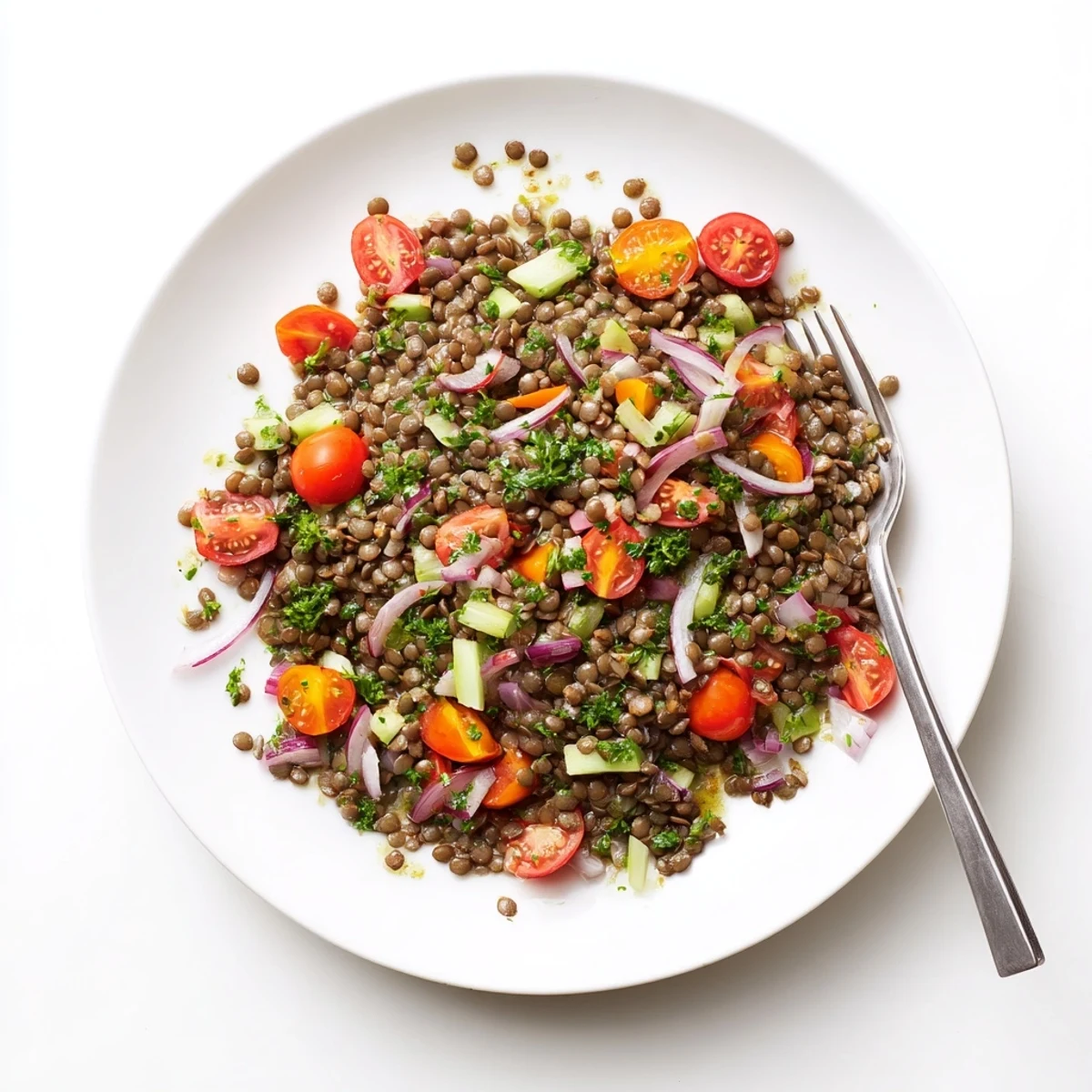 Tender French green lentils tossed with crisp vegetables and zesty Dijon dressing in a white serving bowl
