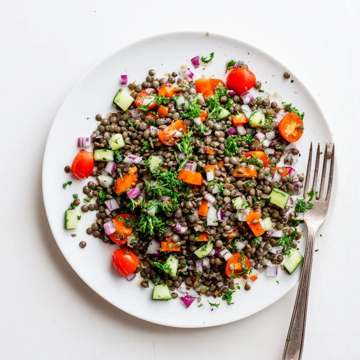 Close-up of French lentil salad featuring diced red onion, carrot, celery and parsley coated in lemon-mustard vinaigrette