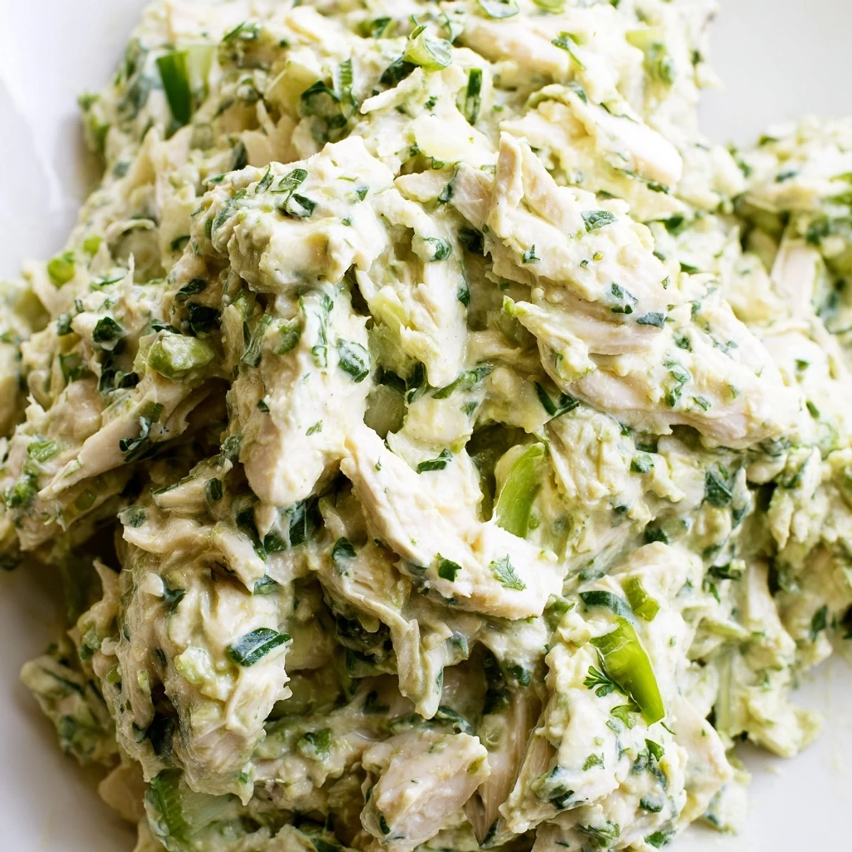 Creamy Green Goddess Chicken Salad Dip topped with fresh herbs and served with crackers for appetizers