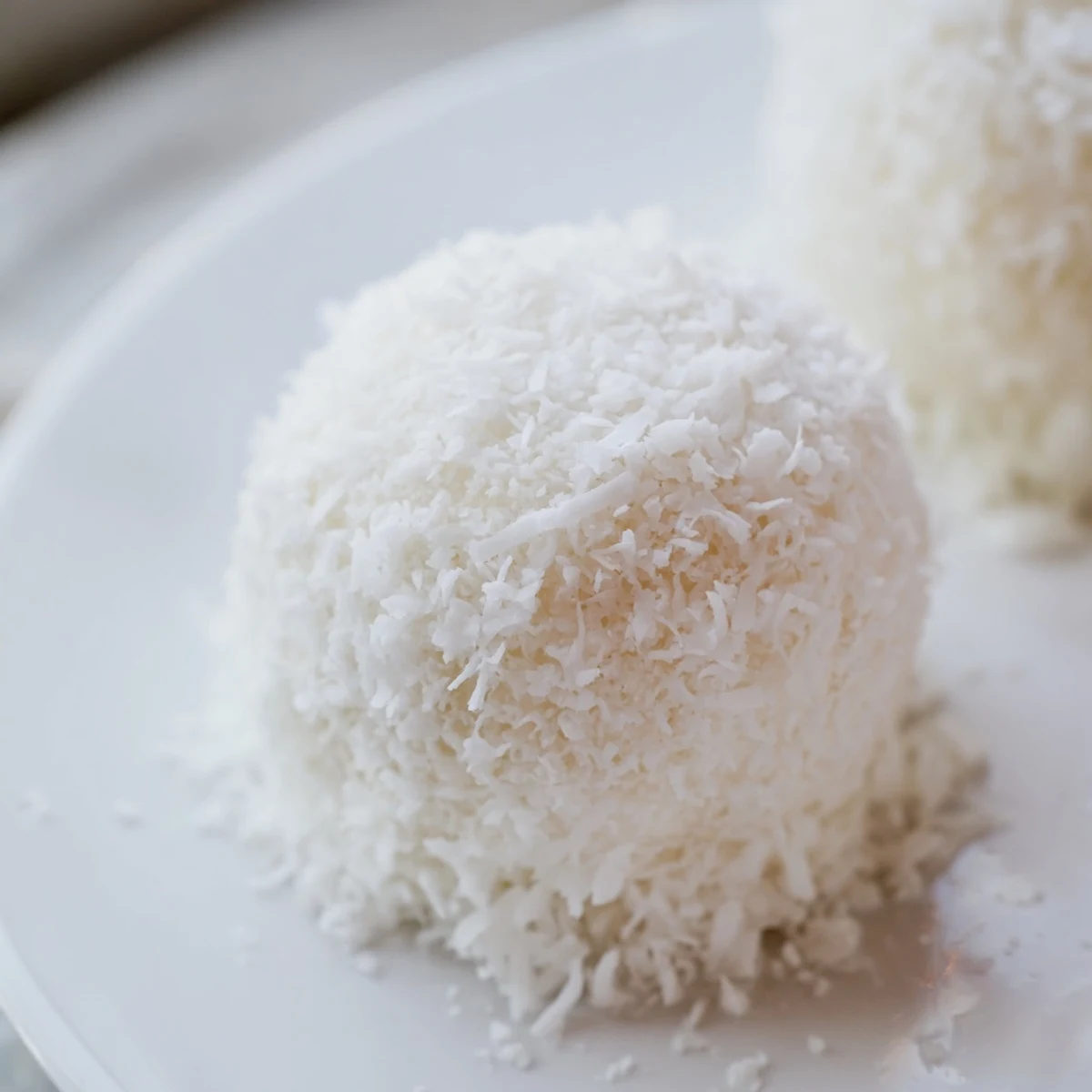 Close-up of snowy white no-bake Easter bunny coconut tails arranged on parchment paper for serving