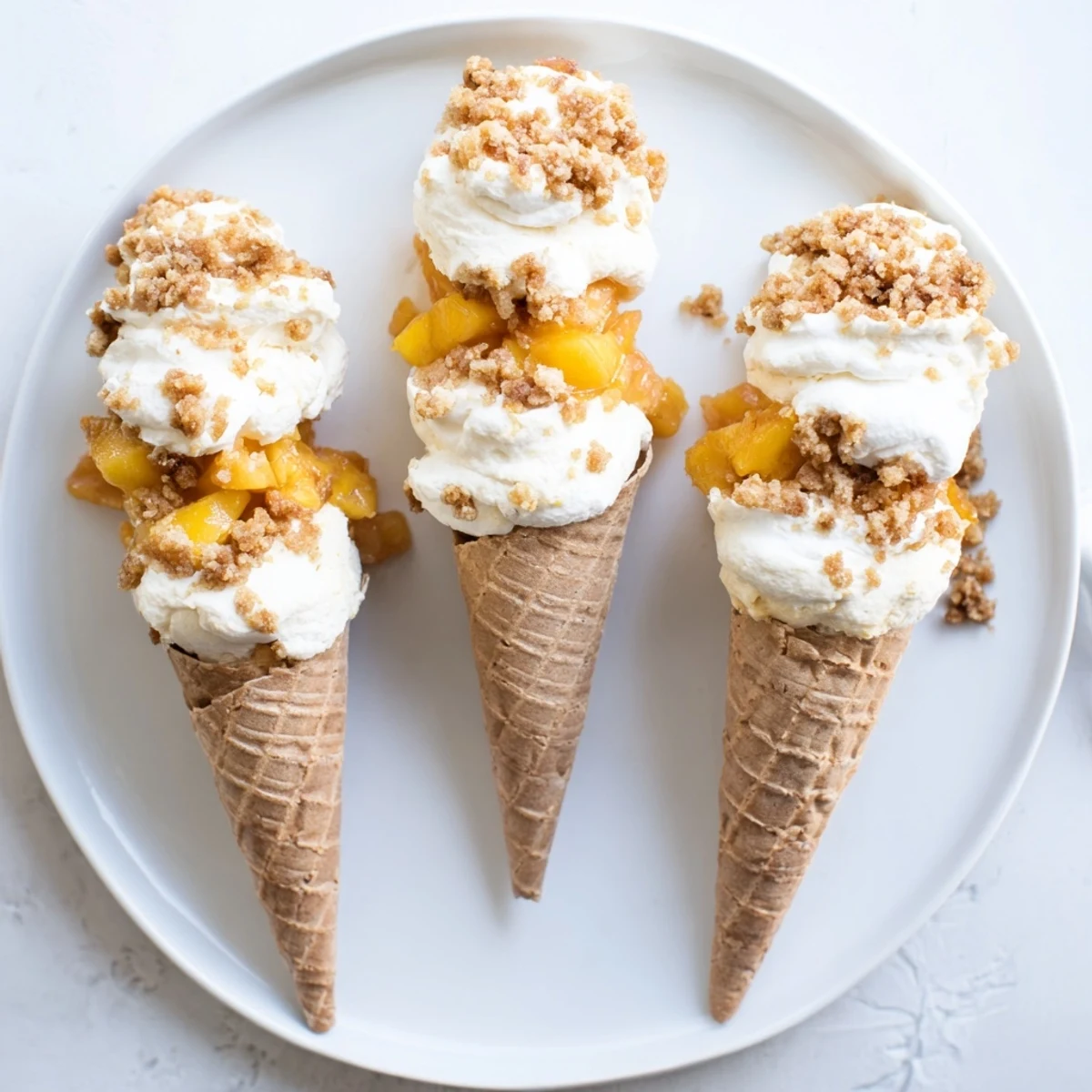 Golden waffle cones filled with creamy cheesecake and sweet peach cobbler topping