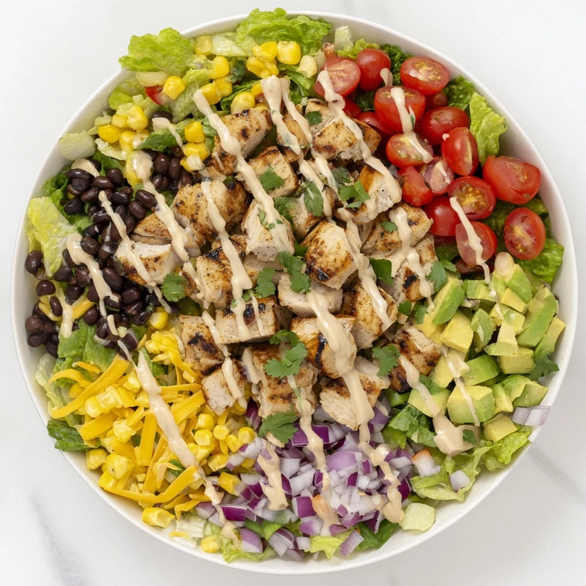 Colorful bowl of healthy BBQ chicken chopped salad with fresh avocado, tomatoes, and grilled chicken