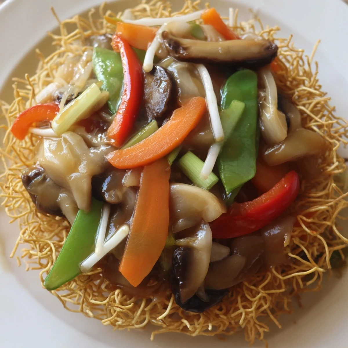 Plate of crispy noodle chow mein served with tender crisp vegetables and aromatic Asian seasoning