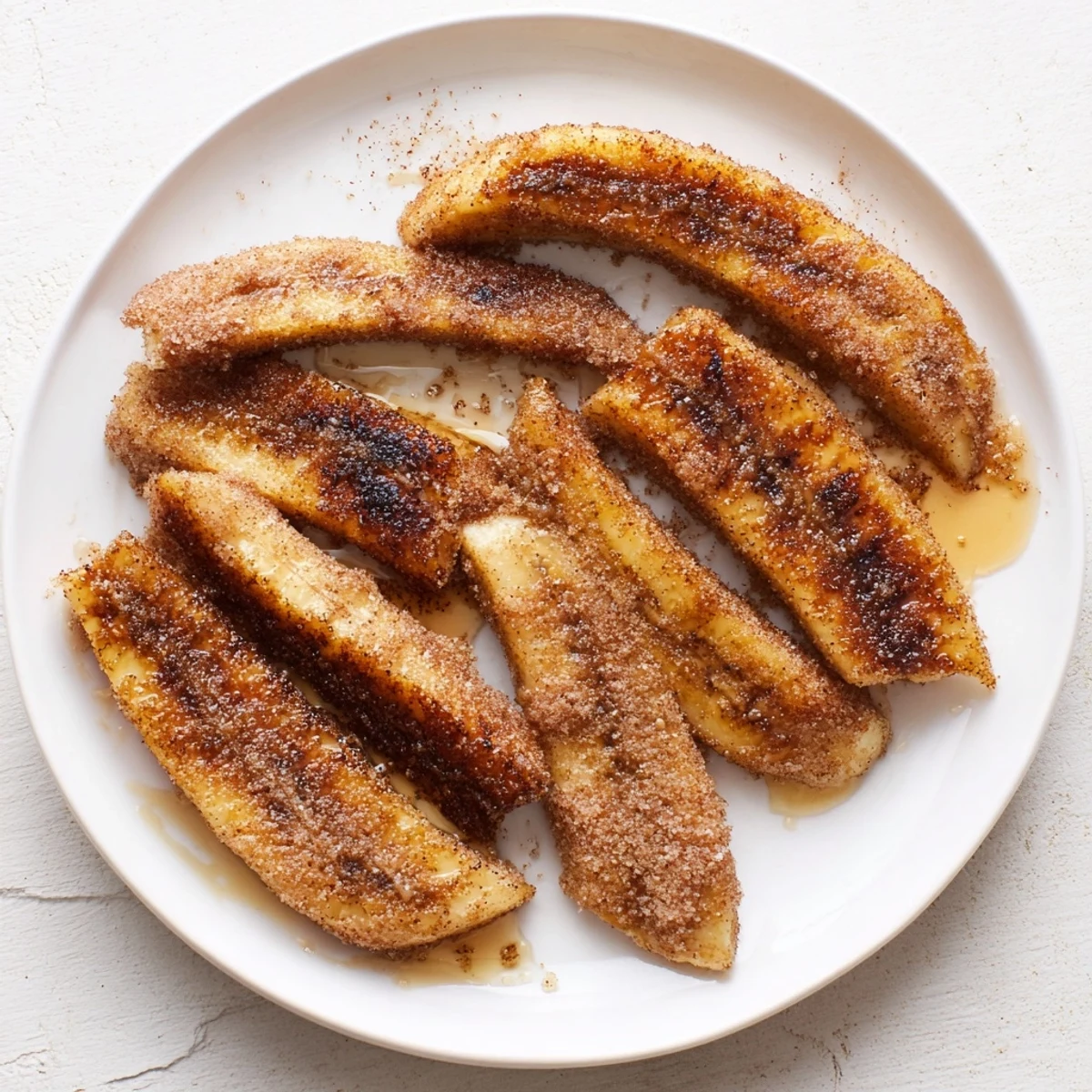 Warm cinnamon banana slices sizzling in skillet with melted butter and sugar