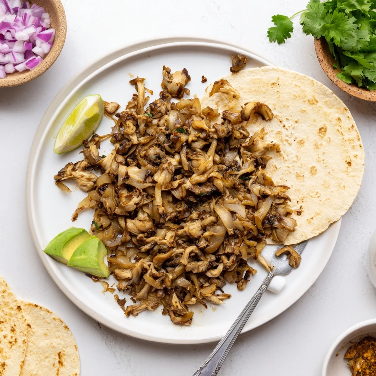 Savory mushroom carnitas tacos topped with fresh cilantro and diced red onion