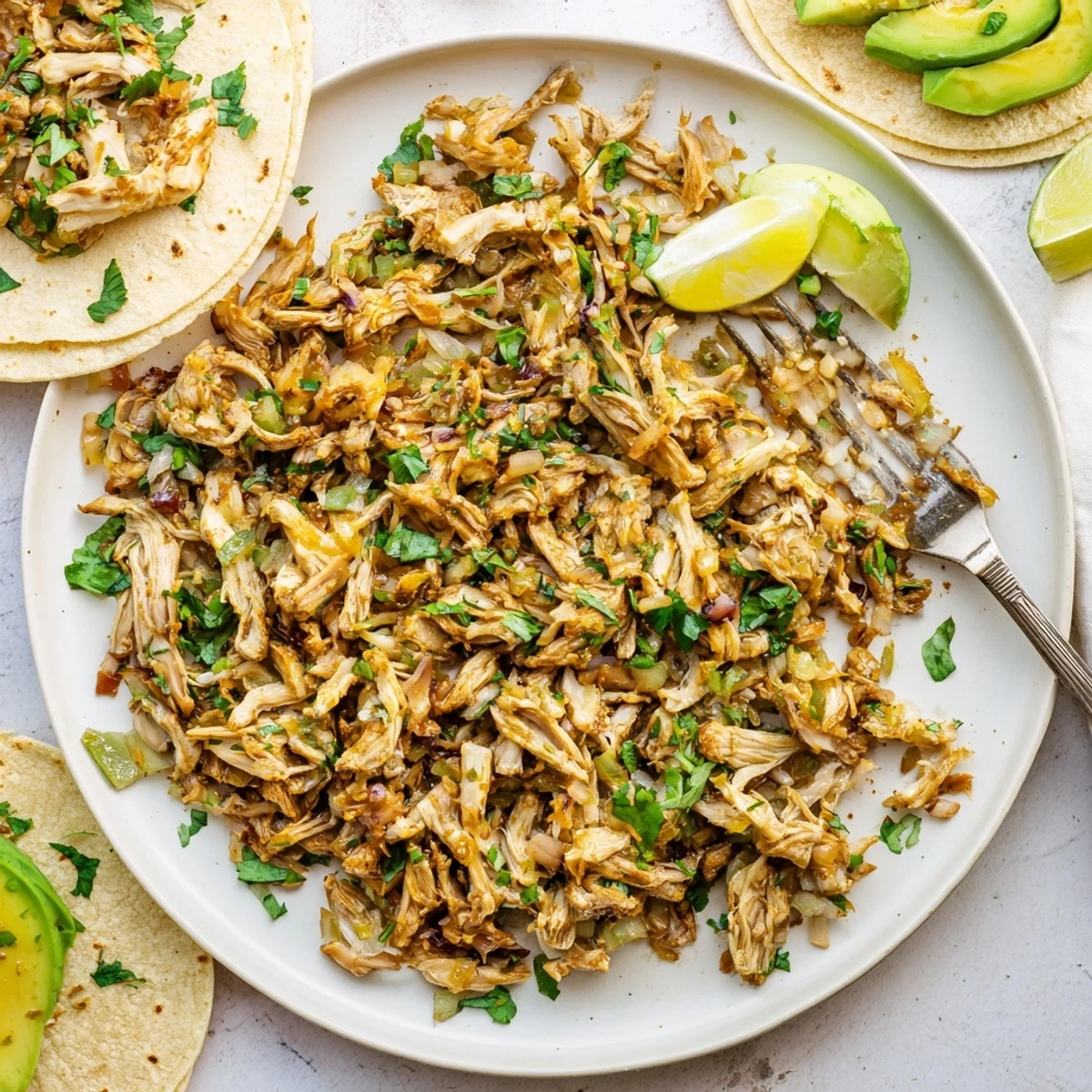 Golden brown vegan carnitas with shredded mushrooms piled in warm corn tortillas