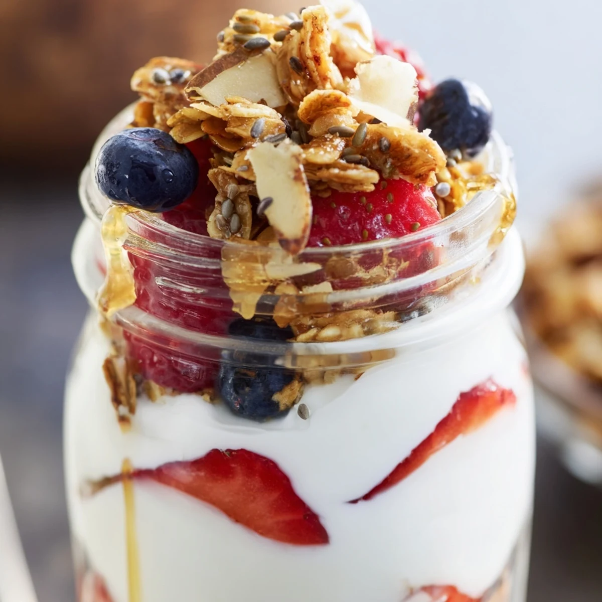 Creamy Greek yogurt parfait layered with fresh berries and crunchy granola in glass