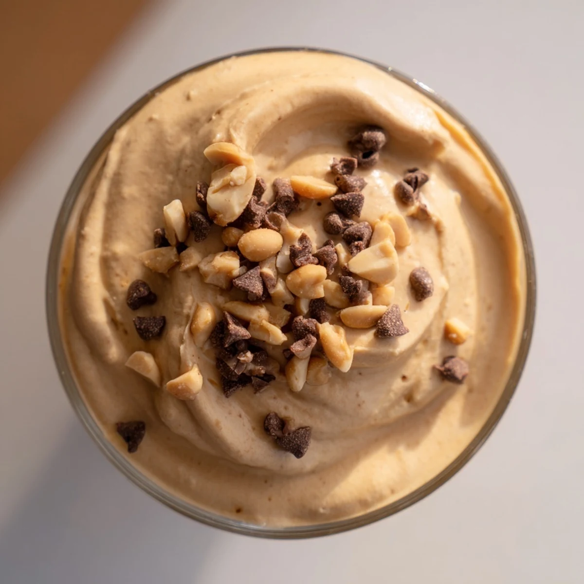 Creamy peanut butter and Cool Whip mousse topped with chocolate shavings and chopped peanuts in glass cups