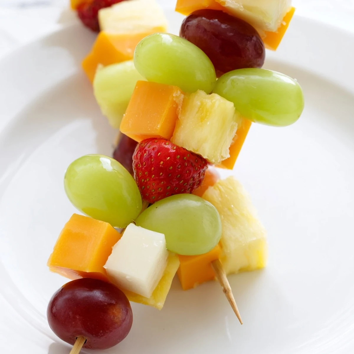 Juicy grapes and pineapple paired with cubed cheddar on wooden skewers