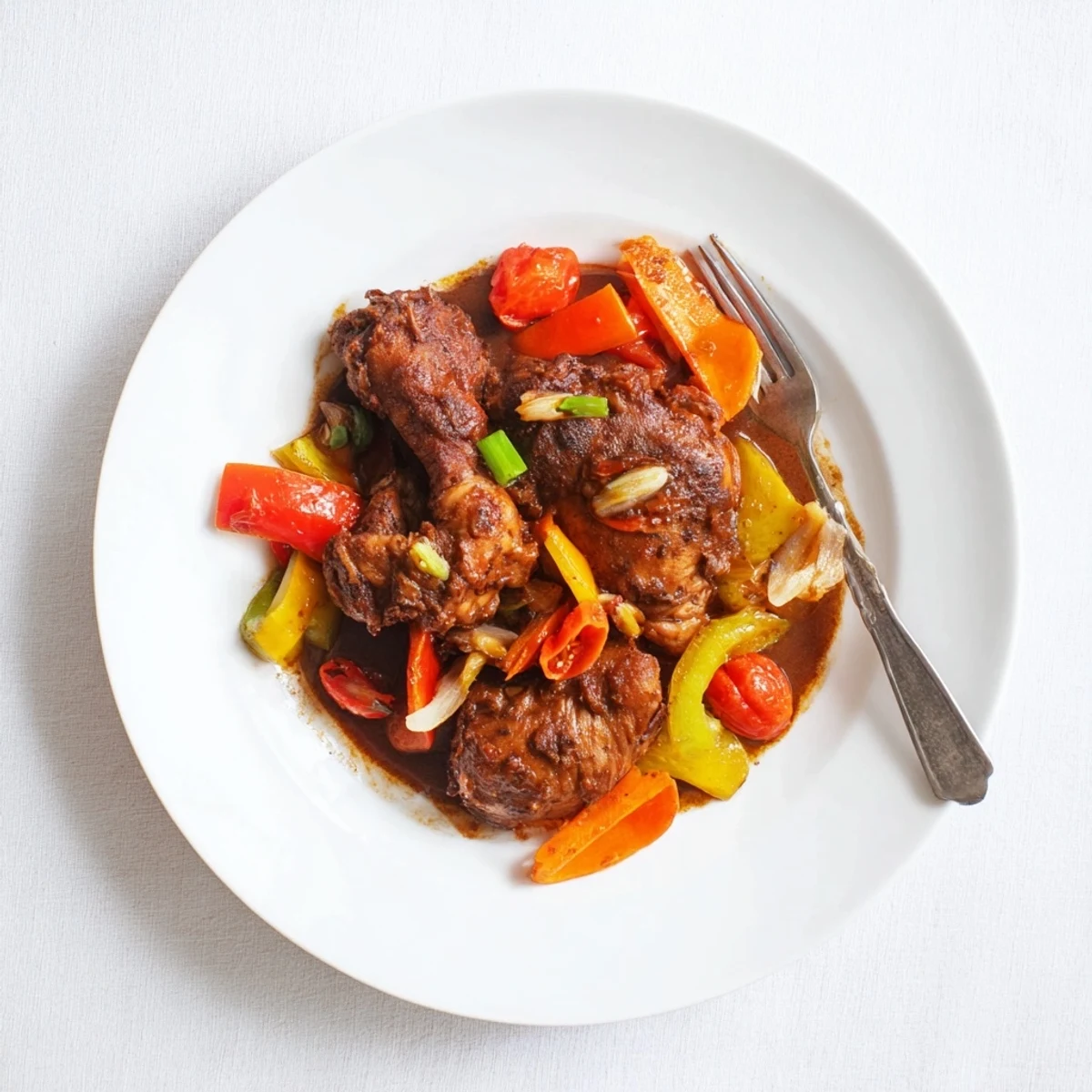 Tender brown stew chicken simmered in a rich, deeply spiced Caribbean gravy over white rice