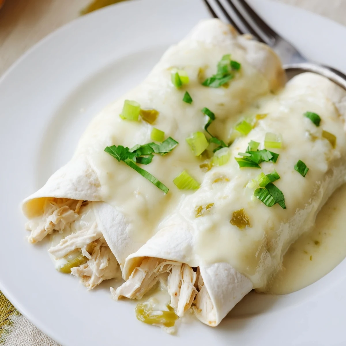 Creamy White Chicken Enchiladas bubbling golden, silky sauce and melted Monterey Jack