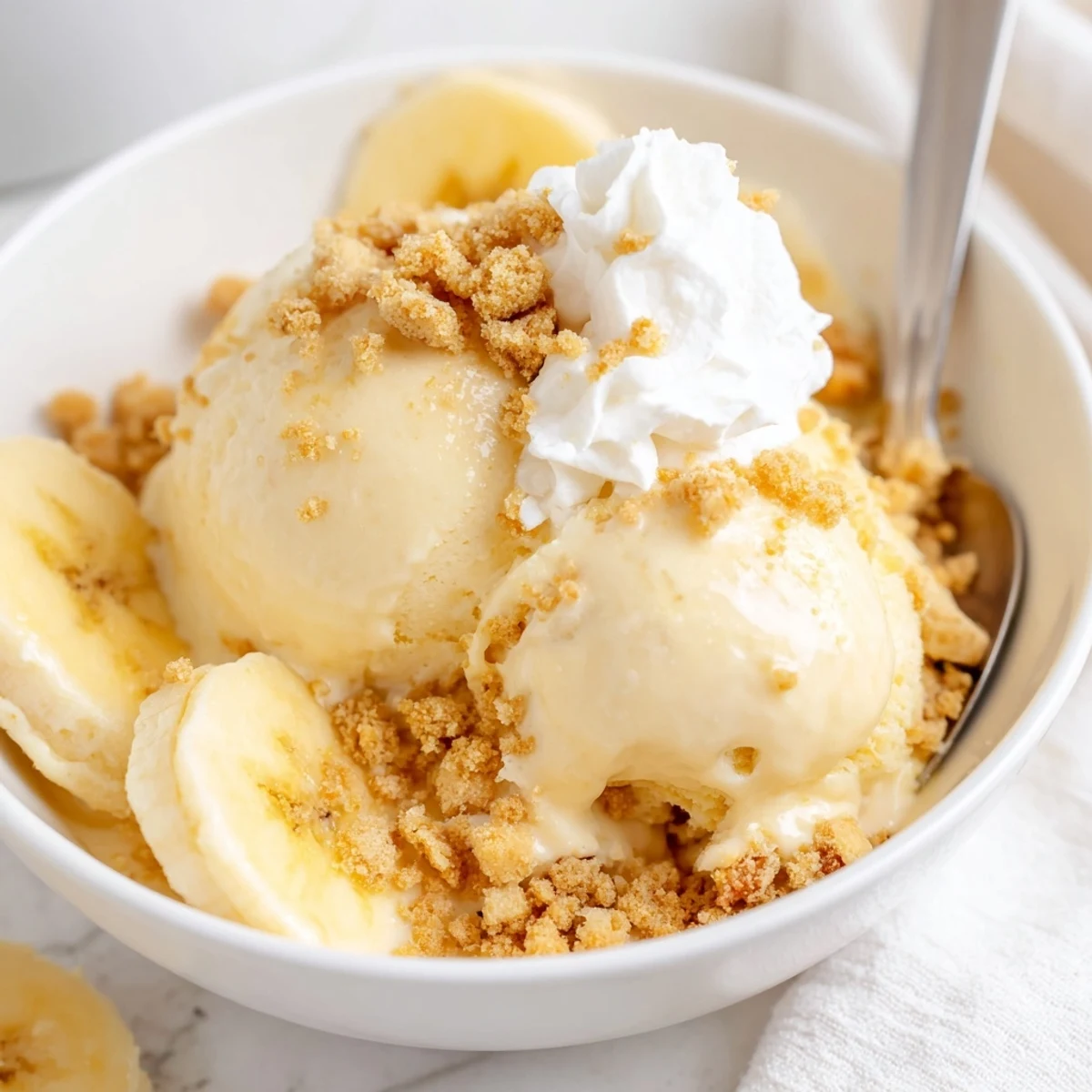 Creamy Ninja Creami Banana Cream Pie Ice Cream served in bowls with sliced banana