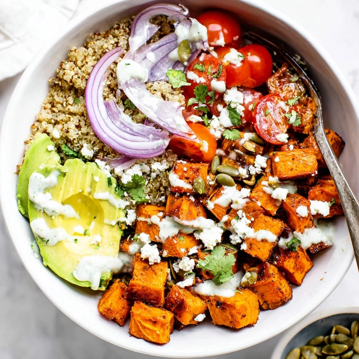 Roasted Sweet Potato Quinoa Salad Bowl with golden caramelized cubes and creamy dressing.