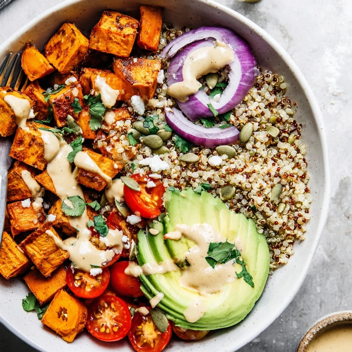 Vibrant Roasted Sweet Potato Quinoa Salad Bowl served warm over bed of greens.