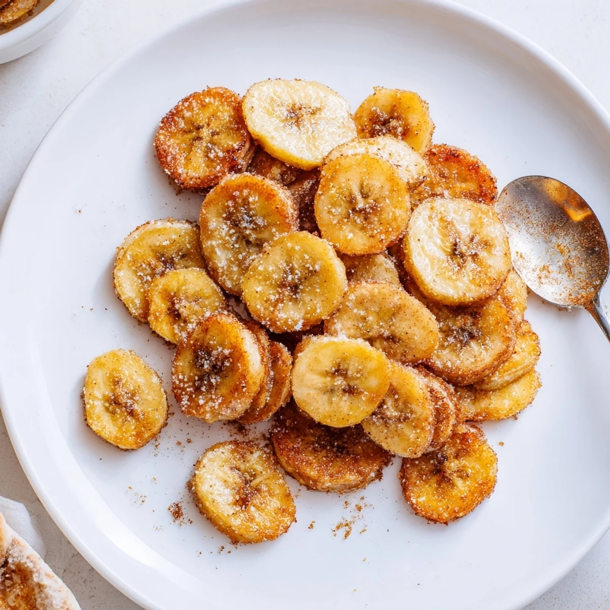 Close-up of Crispy Cinnamon Sugar Air Fryer Banana Chips piled on parchment
