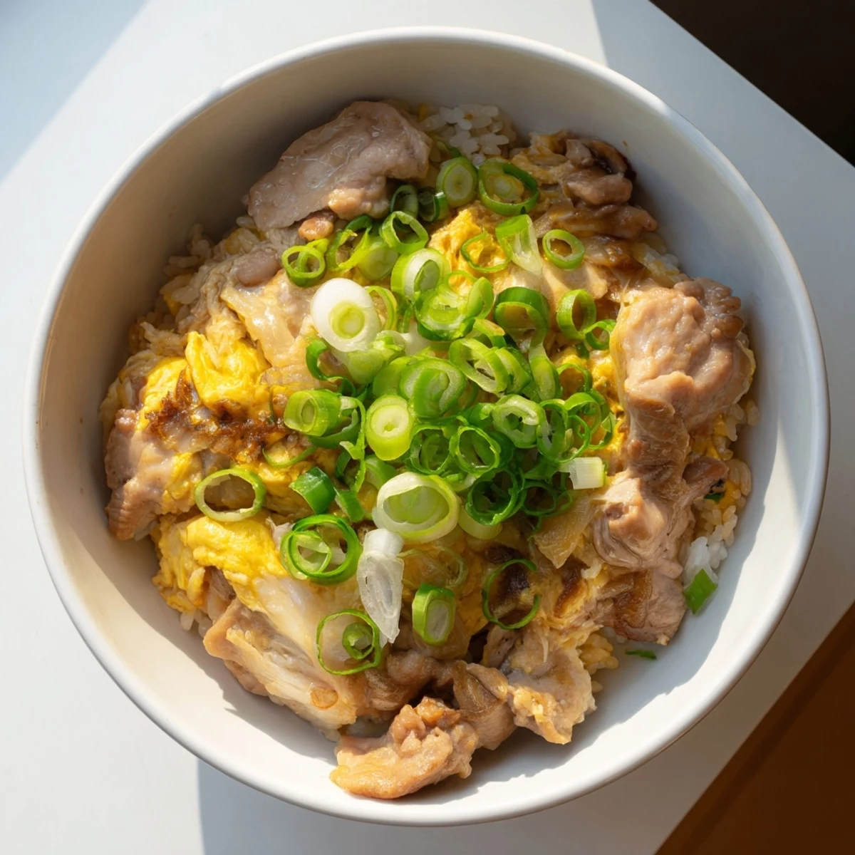 Comforting Japanese Oyakodon simmered in sweet soy dashi broth over steaming white rice