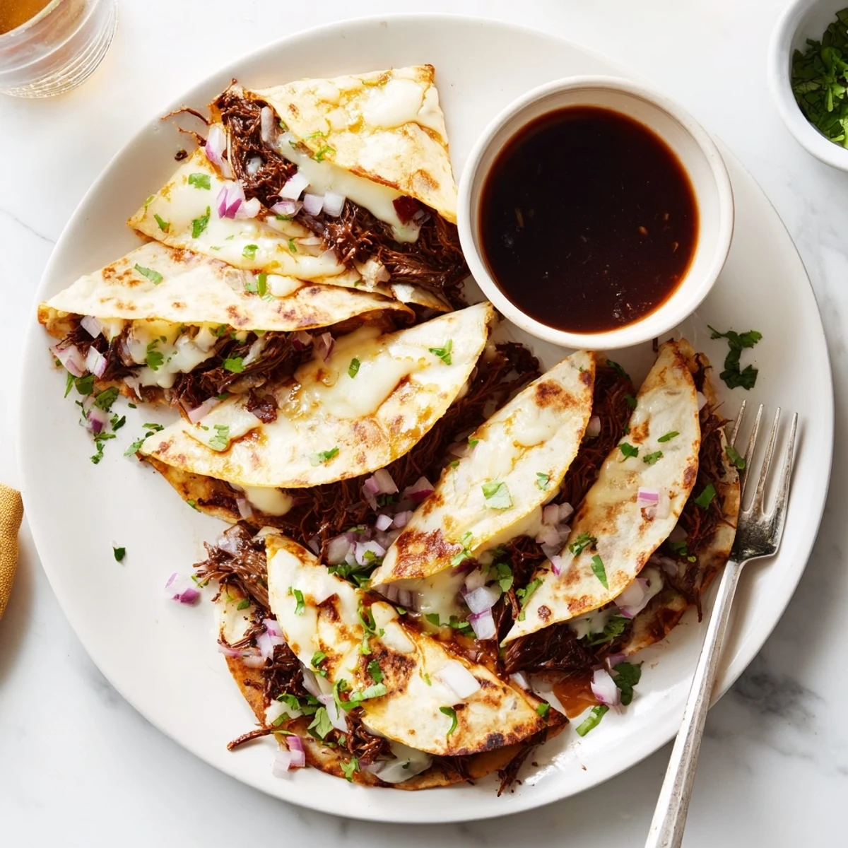 Handheld Birria Tacos featuring juicy slow-cooked meat in cheesy corn tortillas with diced onions