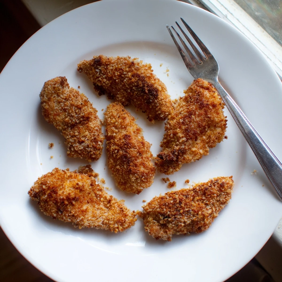Homemade air fryer chicken tenders arranged appetizingly with ranch dipping sauce on the side