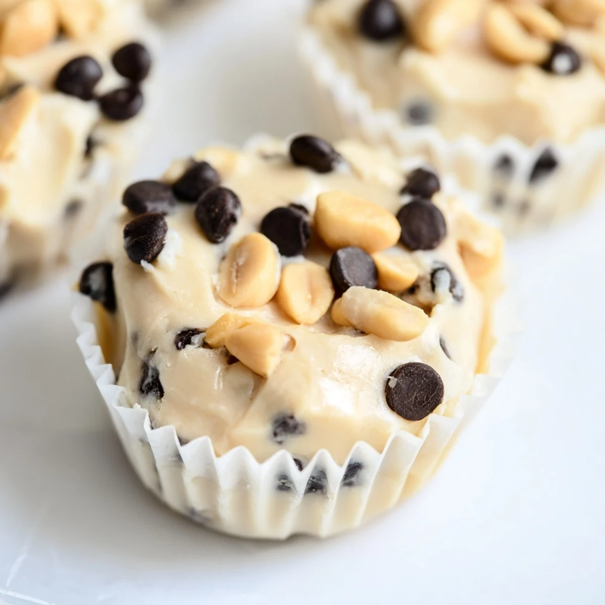 Golden brown peanut butter Greek yogurt bites topped with mini chocolate chips on a white plate
