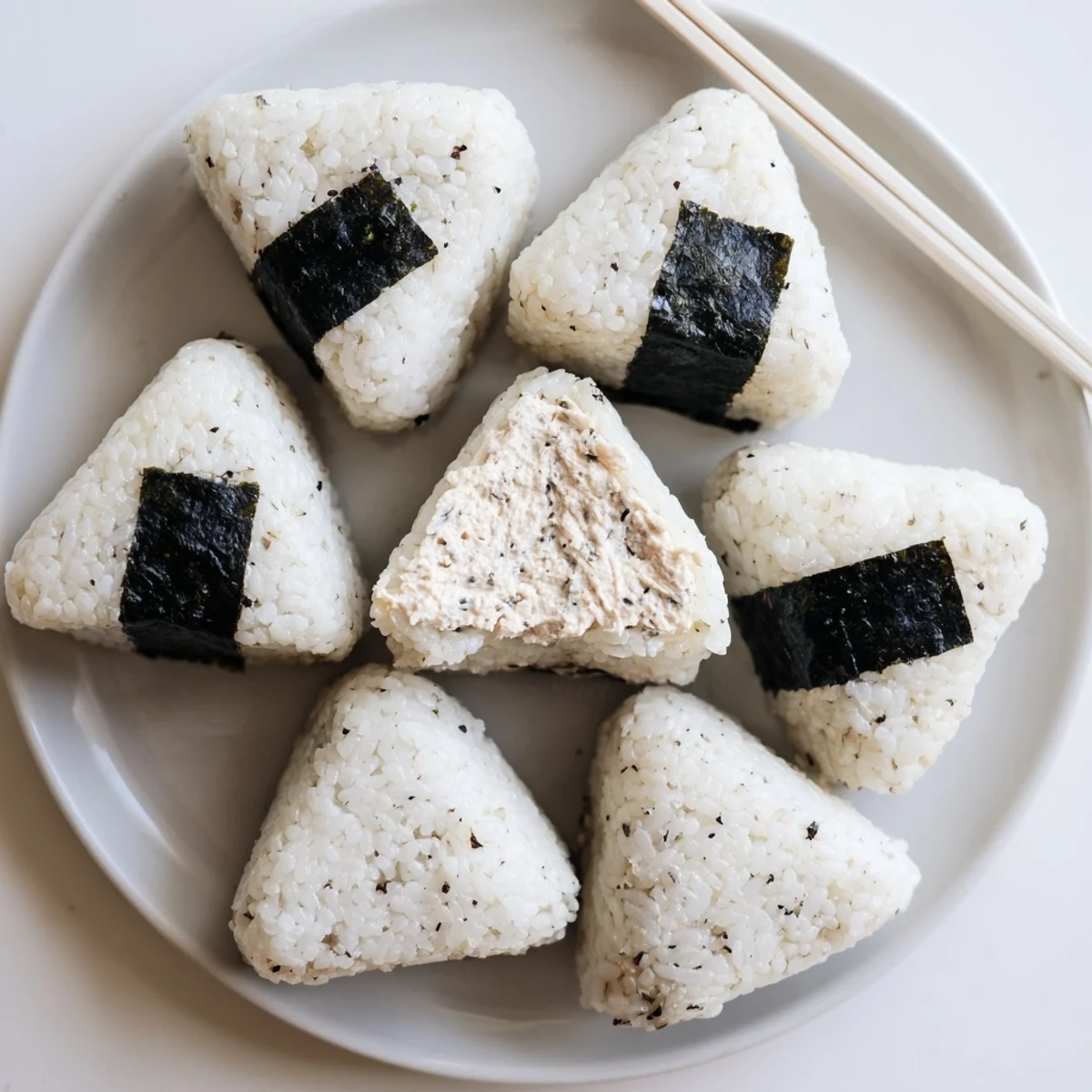 Golden triangular tuna mayo onigiri wrapped in crisp nori seaweed strips