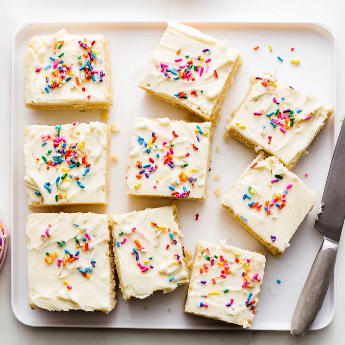 Soft frosted sugar cookie bars topped with creamy colorful frosting and festive sprinkles