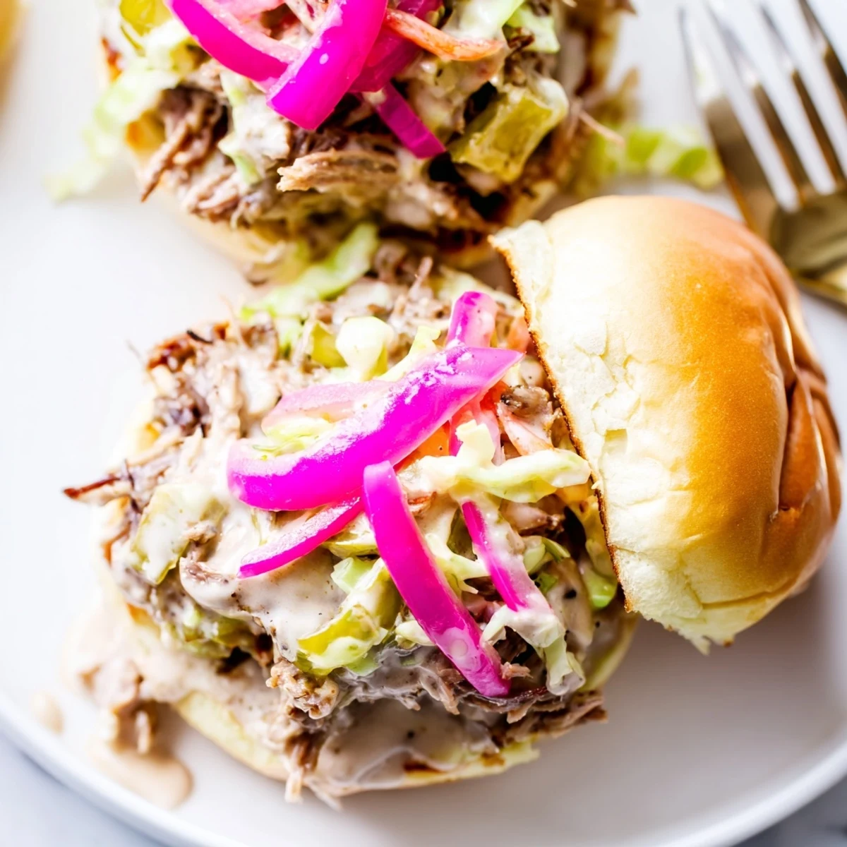 Creamy Alabama white sauce pulled lamb sliders stacked on soft buns with crunchy slaw