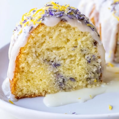 A slice of moist Lemon Lavender Cake showing tender crumb and herbal lavender specks, ready to be enjoyed.